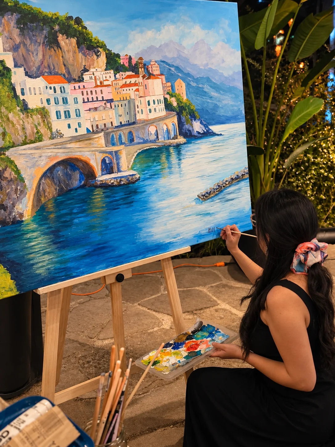 Mimí Palacios pintando una obra de gran formato durante un evento