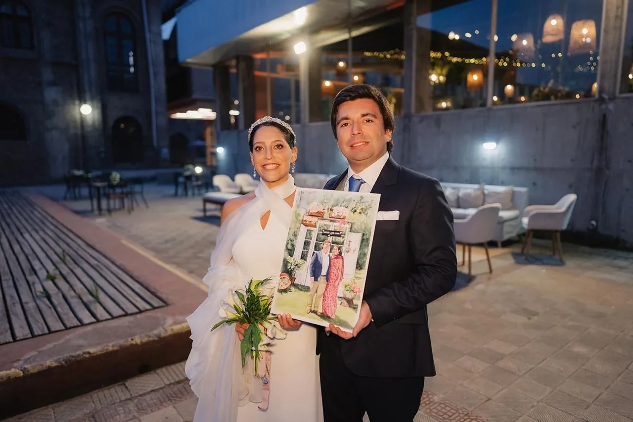 Novios mostrando una acuarela original creada para su matrimonio