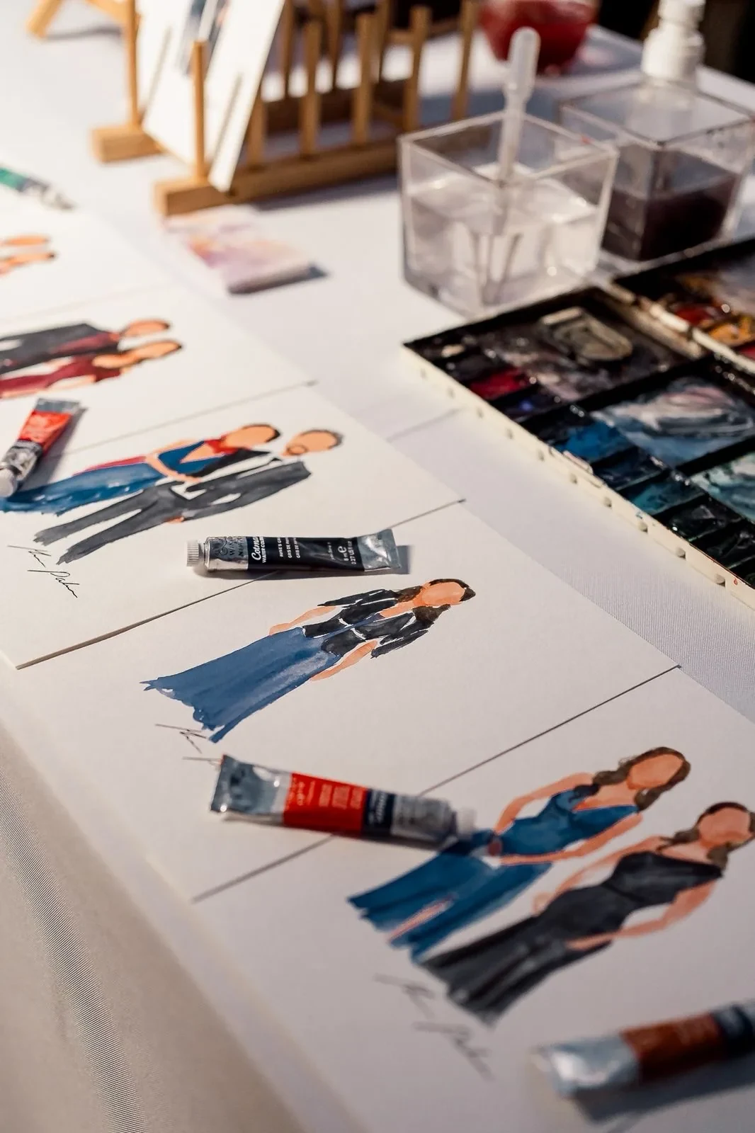Retratos en acuarela y materiales de trabajo durante un evento
