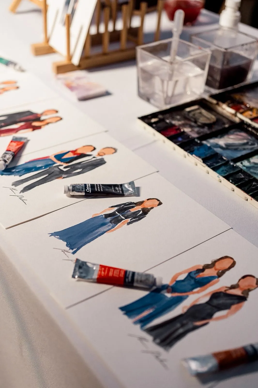 Retratos en acuarela y materiales de trabajo durante un evento