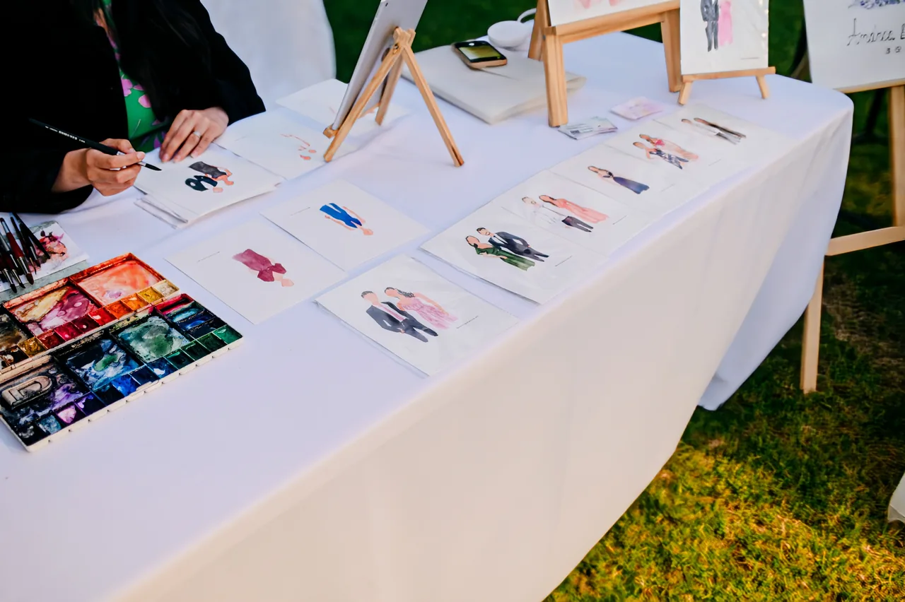 Mesa de trabajo con retratos en acuarela creados en vivo
