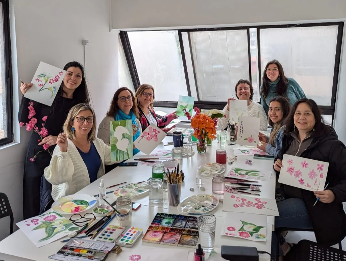 Grupo de jóvenes y adultos mostrando sus trabajos en acuarela